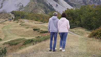 Active senior couple hiking in mountains, enjoying their adventure