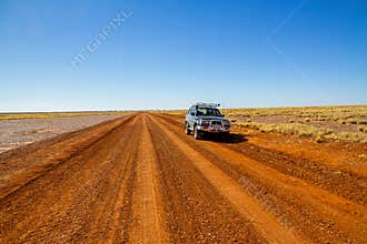 A 4WD on a deserted gravel road in outback country, Australia.