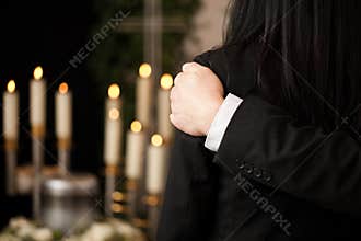 People at funeral consoling each other