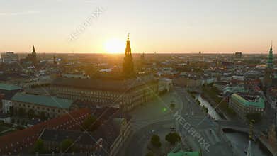 Aerial footage of Christiansborg palace with tall tower at sunset. View of historic city center. Copenhagen, Denmark