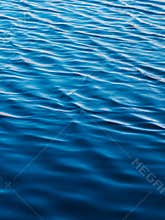 Waves backlit by the light of the setting sun. Transparent. Navy blue. Blue. Background.