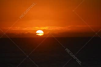 Vibrant Ocean Sunset with Fiery Orange Sky and Clouds
