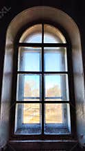 Castle window in a medieval style. Arched window on a facade of medieval wall. Ancient window, old architecture element