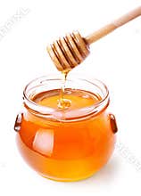 Glass jar of honey with wooden drizzler