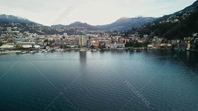 Aerial View of the Lake and the Town of Lugano on the Shore. Drone Shot of the City Near the Water and the Alps in the
