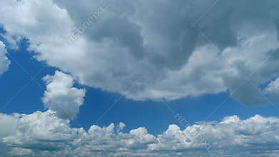 Dark storm cumulus clouds with background. Textured clouds with a dark bottom against a blue sky. Timelapse.