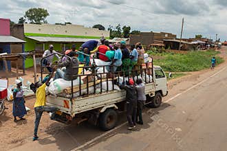 Truck full of passengers and goods at rush hour in an African village.