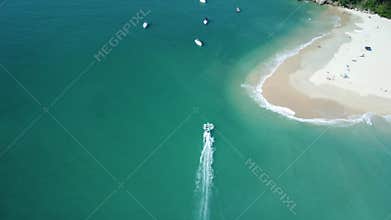 Drone shot of boats in the sea by the beach of Prumirim Island in Ubatuba, Sao Paulo, Brazil