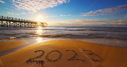 Happy New Year 2023 concept, lettering on the beach. Written text on the sea beach at sunrise