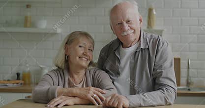 Slow motion of happy couple of senior people smiling and laughing indoors in apartment