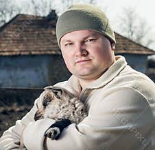 Man embracing a goatling.