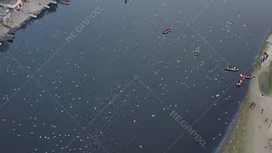 Aerial video of people feeding birds on a fishing boat along the Yamuna river in New Delhi, India.