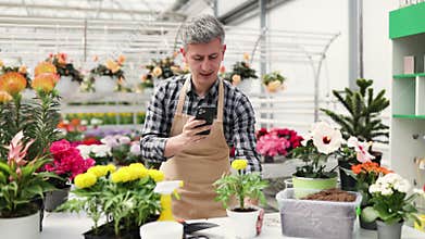 Florist Using Smartphone in Greenhouse