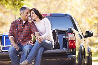 Couple Sitting In Pick Up Truck On Camping Holiday