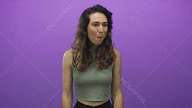 Woman with open mouth and wide eyes against purple studio wall; surprise amazement astonishment shock