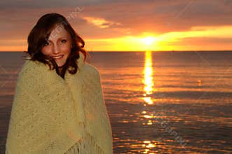 Cozy woman wrapped in blanket at sunset