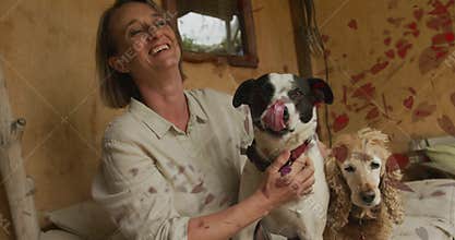 Dog licking owner nose causing woman petting dog while animated leaves drifting in pet care