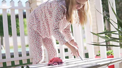 A girl with pajamas is cleaning the table on the veranda. Spain, Alicante