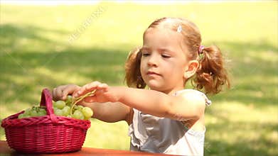 Little girl eat grape
