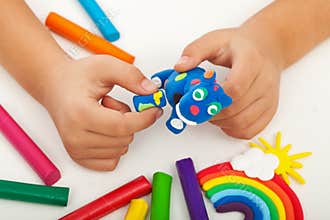 Child playing with colorful clay - closeup on hands
