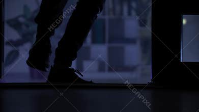 trespassing, young man sneaking indoors at night, legs close up