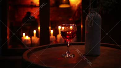 Wine bottle with glass on the wooden barrel cozy bar still life