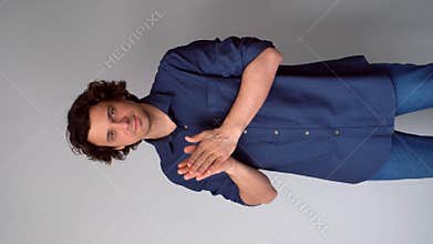 Sneaky scheming curly man rubbing hands plotting cunning idea on gray background