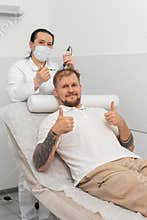 Trichologist doing man improve hair growth procedure, dermapen microneedling, vitamin injections