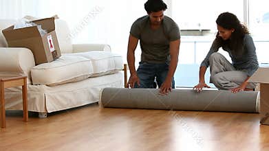 Couple rolling a carpet