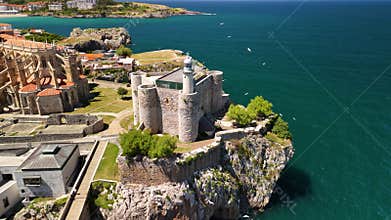 Drone view of seabirds flying near Santa Ana Castle-Lighthouse on a seafront cliff