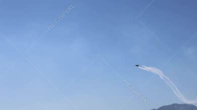 The F16 fighter performs aerobatics over the sea against the background of mountains