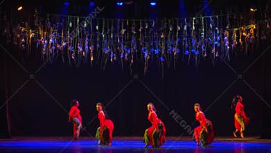 Five Women Perform Traditional Dance on Stage with Blue Lighting and Hanging Decorations