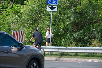 Cyclist And Jogger Using Shared Urban Bicycle Route