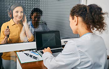 Mature woman at a hearing test at audiology center. Audiometry, hearing checkup