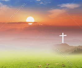 Solitary White Christian Cross on Misty Hilltop against Vibrant Morning Sun