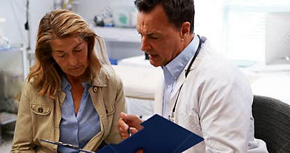 Doctor and senior woman discussing over a report