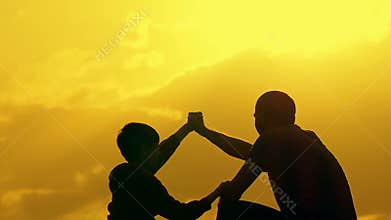 Father and son shake hands in agreement. Happy family having fun in the evening Beautiful nature landscape.