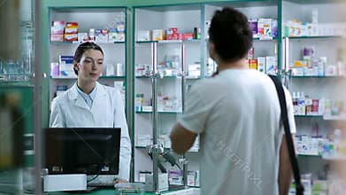 Pharmacist giving advice to customer on medication