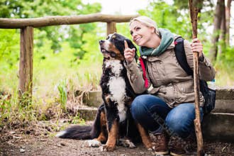 Hiking woman with her dog on a trail