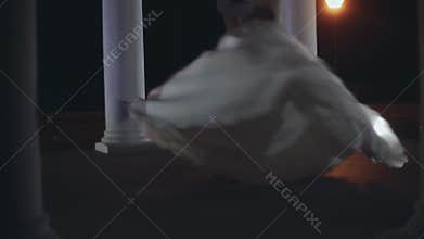 First dance of newlyweds couple in wedding ceremony. Groom turning around the bride in white dress in evening.