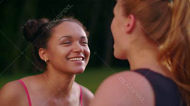 Multi racial girlfriends talking in summer park. Closeup of multi ethnic girls