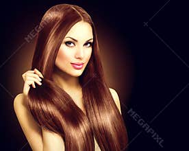Beautiful brunette woman touching her long hair