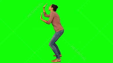 Casual woman crouching with hands up