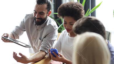 Friends with smartphone and tablet pc in office