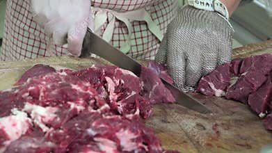 A butcher cutting meat cubes