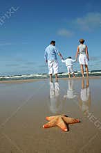 Starfish and tranquil family on the beach