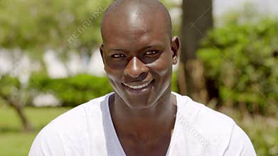Smiling handsome bald black man in the park