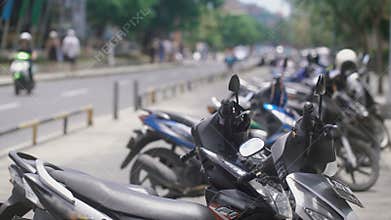 Close up of an Indonesian stop place for bikes. Indonesian mopeds are standing on parking area in Bali. Typical Balinese