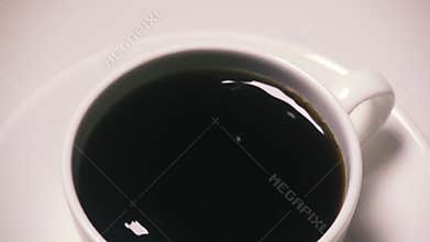 Slow mo in a cup of coffee is added to sugar