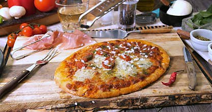 Grating parmesan cheese over pizza margherita